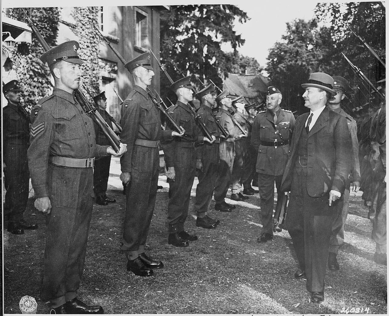 UK Prime Minister Clement Attlee inspects the honour guards consisting of Scots Guards on the lawn of his villa