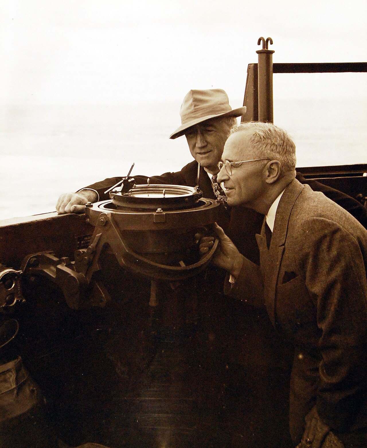 80-G-49924: Potsdam Conference, 17 July – 2 August 1945. President Harry S. Truman onboard USS Augusta (CA 31) en-route to Antwerp for the “Big Three” Conference. Shown: The President taking a bearing of USS Philadelphia (CL 41) which is ahead of them on the pelorus. Photograph received July 18, 1945. U.S. Navy Photograph, now in the collections of the National Archives. (2016/02/23).