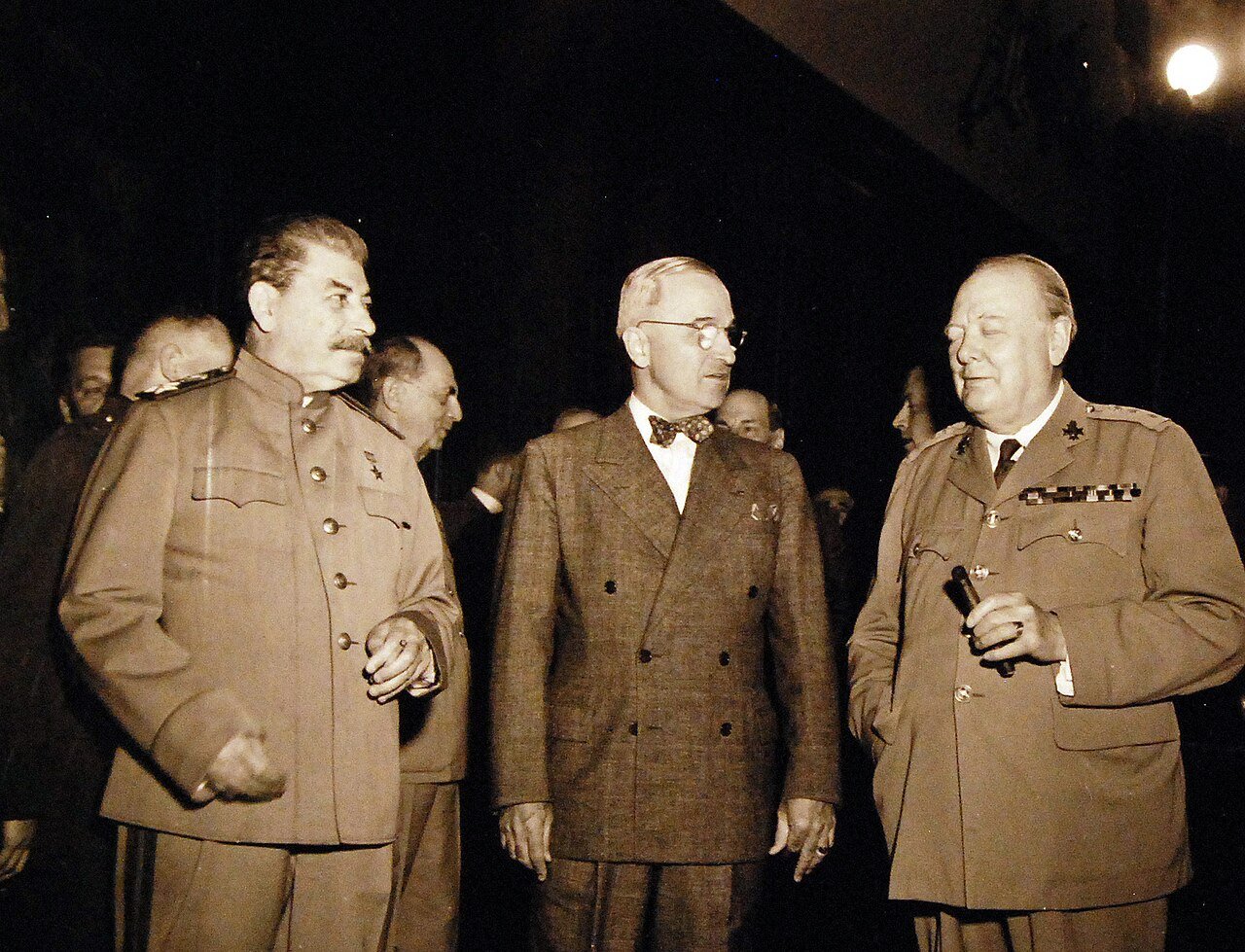 80-G-49958: Potsdam Conference, 17 July – 2 August 1945. The “Big Three” in conference room at Potsdam, Germany, just before start of the first session. Shown: Premier Joseph Stalin, President Harry S. Truman, and Prime Minister Winston Churchill chatting informally. Photograph received July 18, 1945. U.S. Navy Photograph, now in the collections of the National Archives. (2016/02/23).