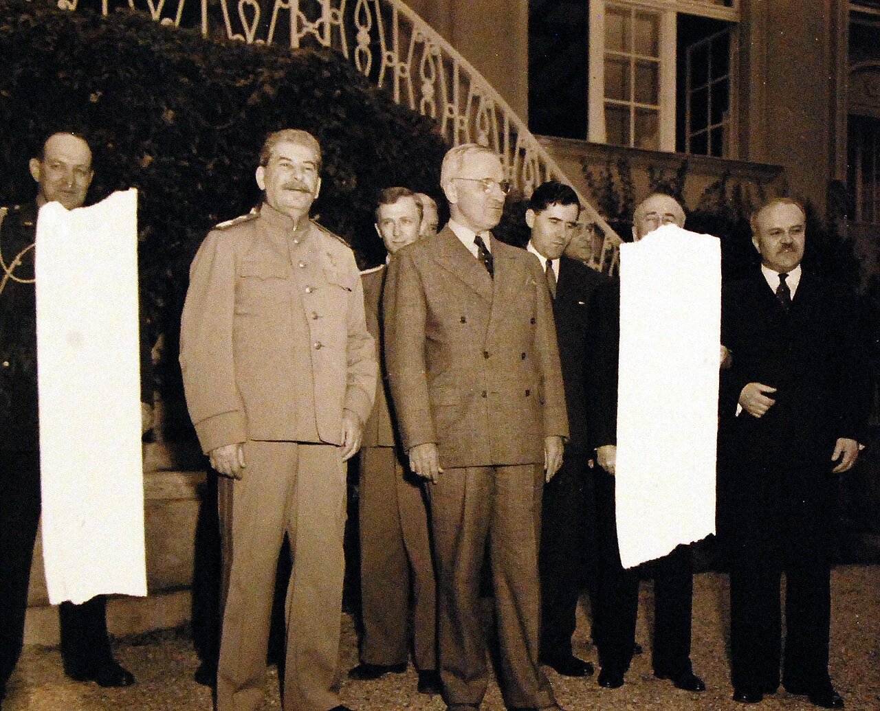 80-G-49959: Potsdam Conference, 17 July – 2 August 1945. Shown: President Harry S. Truman and Secretary of State James F. Byrnes visiting Premier Joseph Stalin and Foreign Commission V. Molotov at Stalin’s residence in the conference area, Potsdam, Germany. Men in Second Row are interpreters. Photographed by CPhoM Wm. Belknap, received July 18, 1945. U.S. Navy Photograph, now in the collections of the National Archives. (2016/02/23).