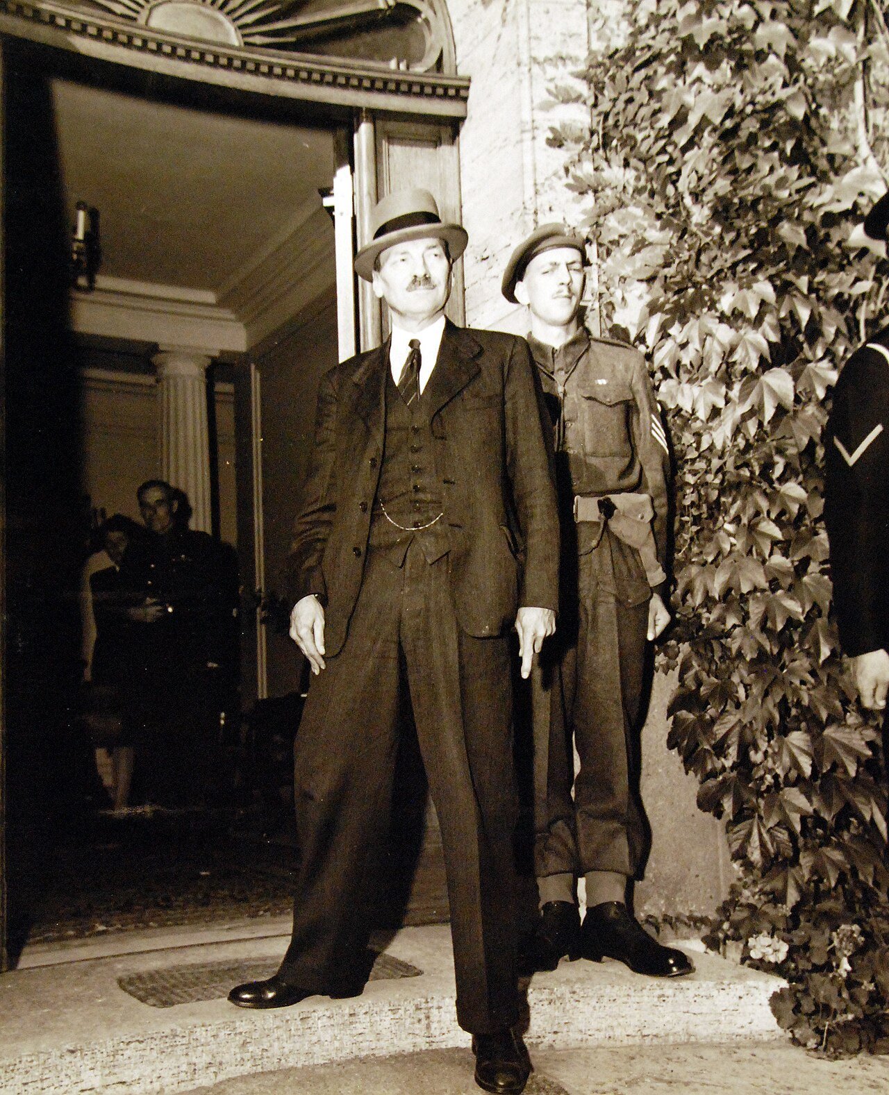 80-G-700187: Potsdam Conference, 17 July – 2 August 1945. Clement Atlee, new Prime Minister of Great Britain, returns to Potsdam, Germany, for further “Big Three” conferences. He is about to enter house formerly occupied by Winston Churchill. Photographed by CPhoM William Belknap Jr., released July 28, 1945. U.S. Navy Photograph, now in the collections of the National Archives. (2016/02/23).