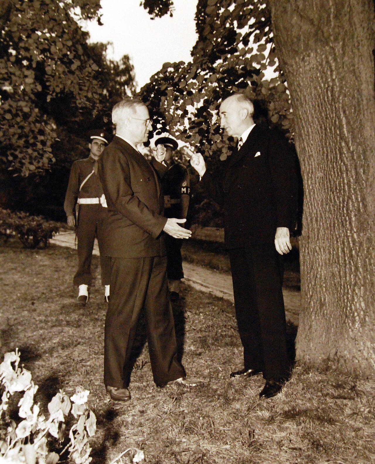 80-G-700196: Potsdam Conference, 17 July – 2 August 1945. President Harry S. Truman and Secretary of State James F. Byrnes engaged in weighty discussion in garden of “Little White House” in Potsdam, Germany. Photographed by CPhoM William Belknap Jr., released July 28, 1945. U.S. Navy Photograph, now in the collections of the National Archives. (2016/02/23).