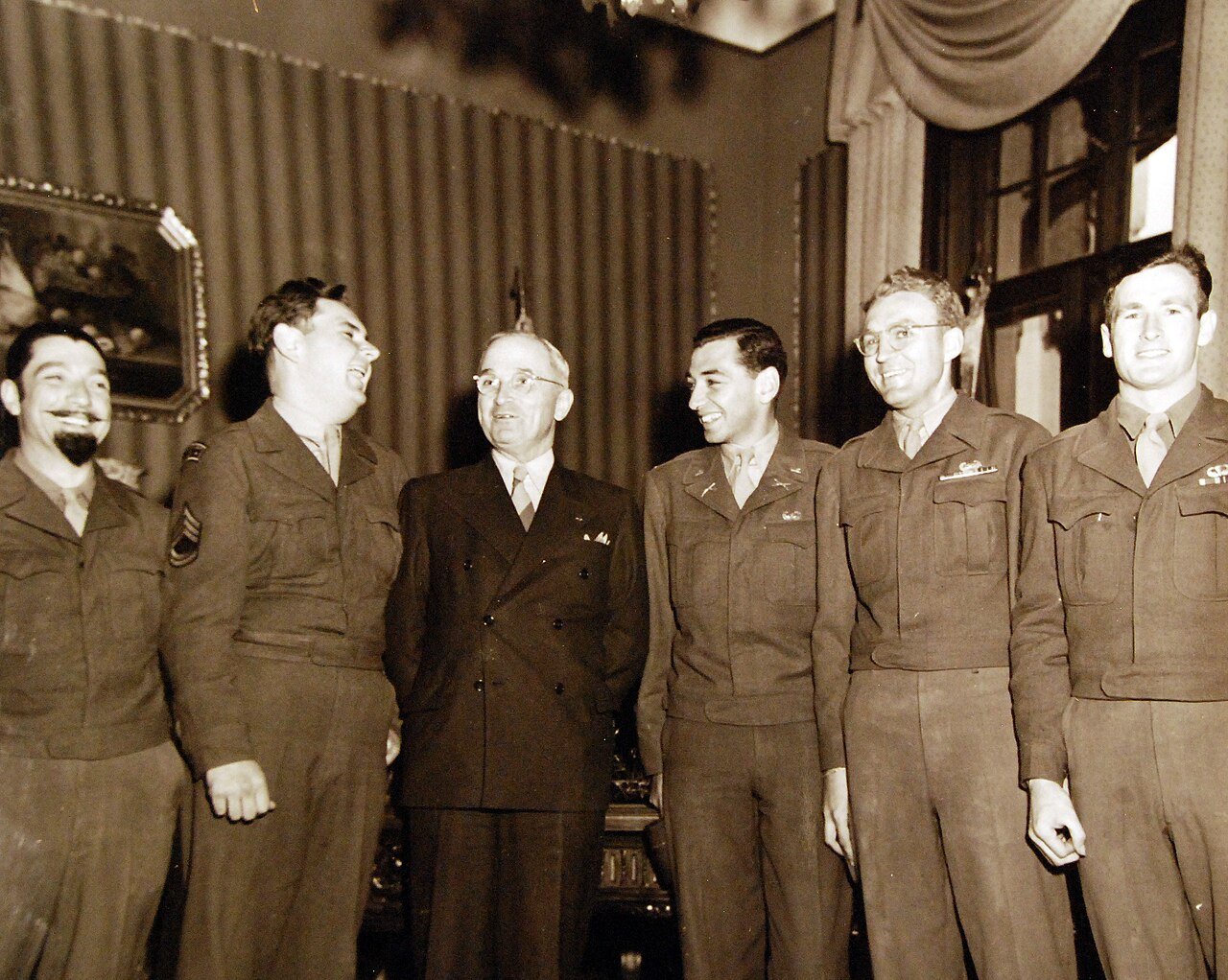 80-G-700198: Potsdam Conference, 17 July – 2 August 1945. Correspondents and photographers of 1st Airborne Army stationed at U.S. Headquarters in Berlin District visit President Harry S. Truman at the “Little White House” in Potsdam, Germany. Left to right: T/S Spero Galanpolo, T/SGT William E. Hancock, the President, 1st LT Robert Schulberg, Sgt Joseph Ryan and Sgt. Russell M. Saunders. Photographed by CPhoM William Belknap Jr., released July 28, 1945. U.S. Navy Photograph, now in the collections of the National Archives. (2016/02/23).