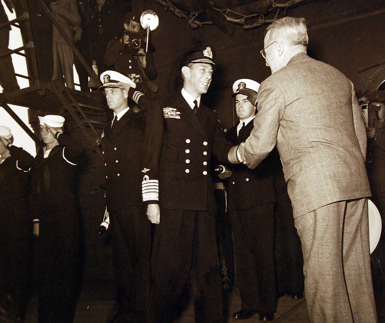 80-G-700227: King George VI aboard USS Augusta (CA 31) for a return visit to President Harry S. Truman while the ship is in Plymouth Harbor, England. President Harry S. Truman welcomes the king aboard. Photograph released August 1945. U.S. Navy Photograph, now in the collections of the National Archives. (2016/02/23).