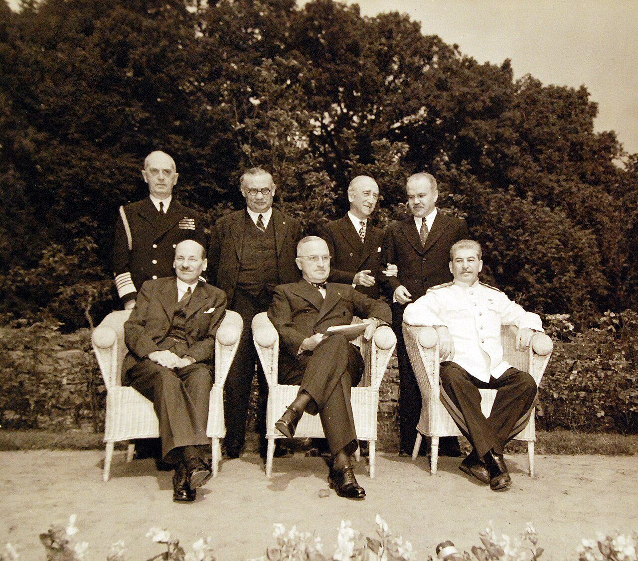 80-G-700277: Potsdam Conference, 17 July – 2 August 1945. Prime Minister Clement Atlee; President Harry S. Truman and Premier Joseph Stalin posing in garden at Potsdam, Germany. In back are Fleet Admiral William D. Leahy; Ernest Bevin; Secretary of State James F. Byrnes, and V. Molotov. Photographed released July 31, 1945. U.S. Navy Photograph, now in the collections of the National Archives. (2016/02/23).