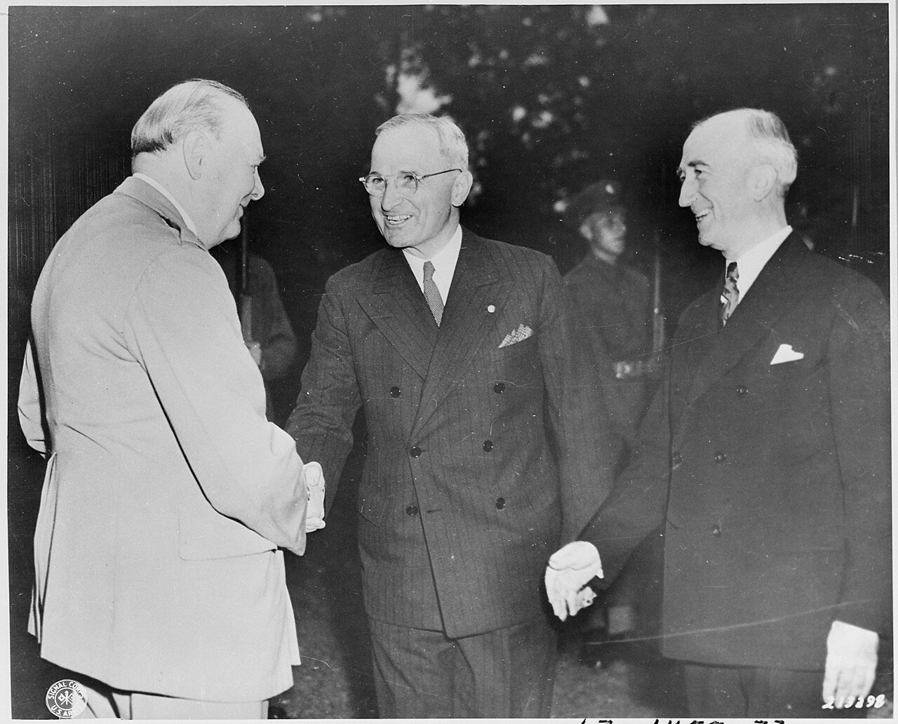 British Prime Minister Winston Churchill greets two of his dinner guests in the garden of his residence during the…