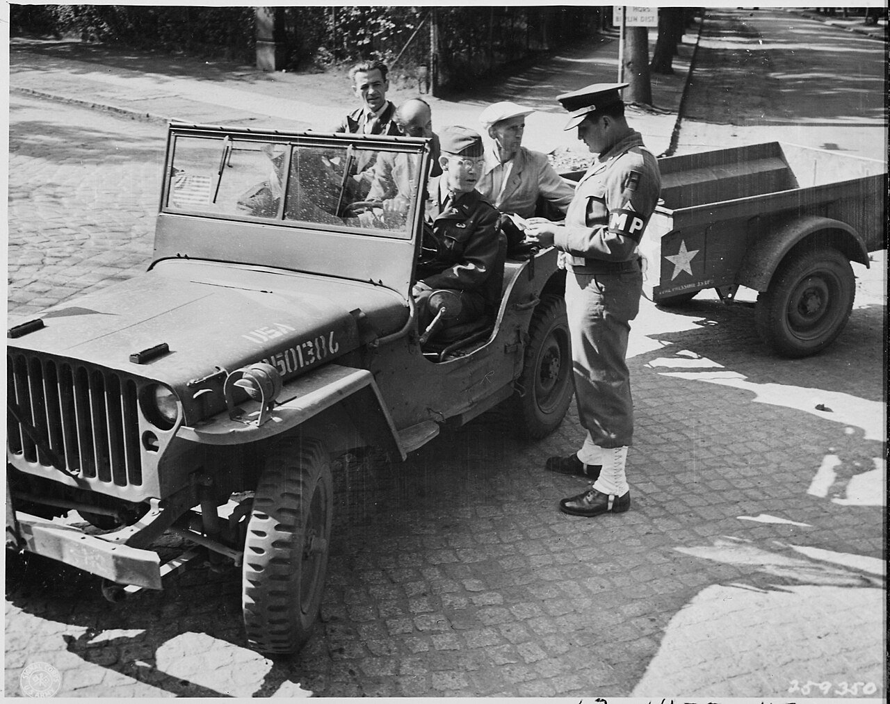 Civilian Photo Technicians (in back of jeep) working for Counter Intelligence Corps, are accounted for by Captain…