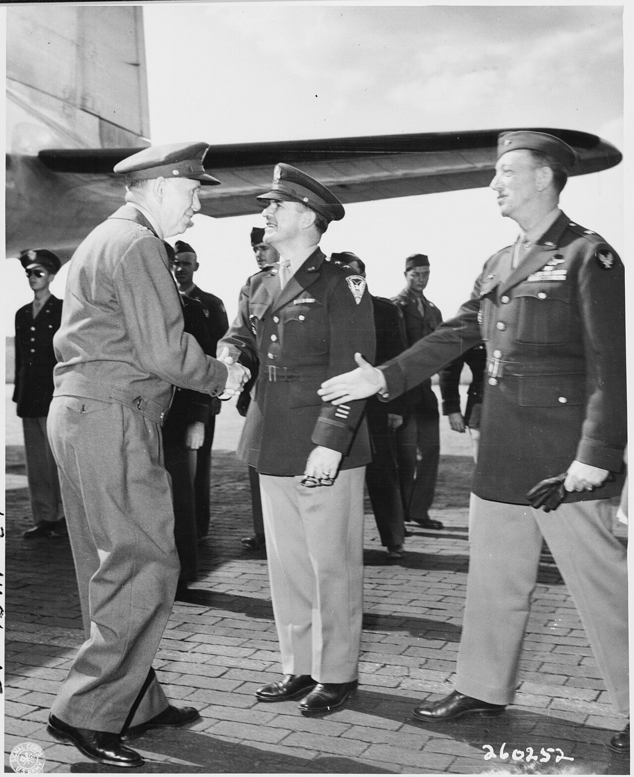 Gen. George C. Marshall shakes hands with Maj. Gen. John R. Deane, center, as Brig. Gen. Ben Stewart Cutler extends…