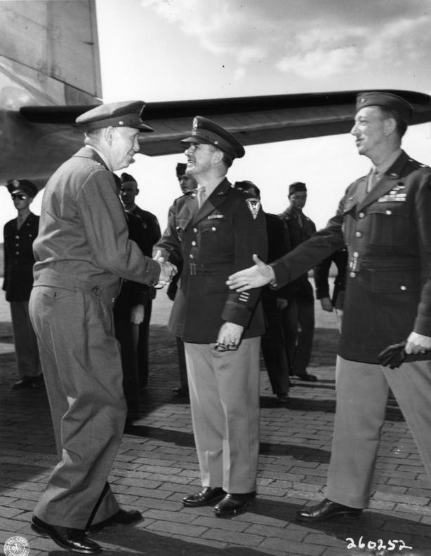 General George C. Marshall (left) shakes hands with Major General John R. Deane, center, as Brigadier General Stuart Cutler extends his hand in greeting. He is arriving for the Potsdam Conference.