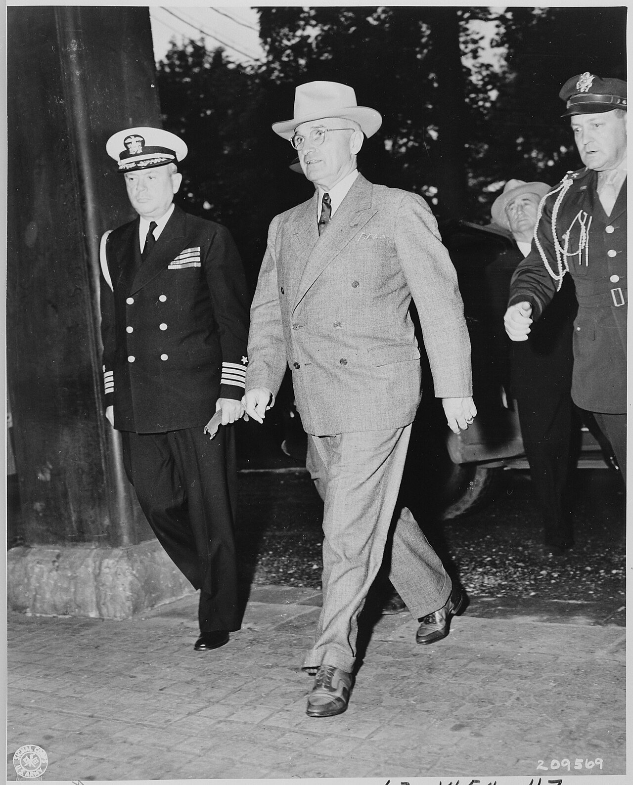 President Harry S. Truman enters Cecilienhof Palace to attend one of the meetings of the Potsdam Conference. L to R…
