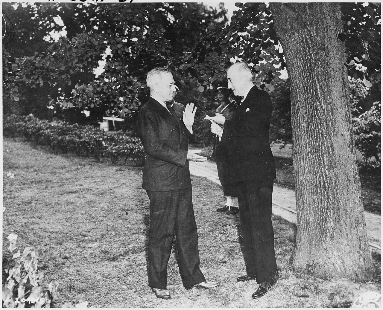 President Harry S. Truman (left) and Secretary of State James Byrnes talk together on the grounds of the "Little…