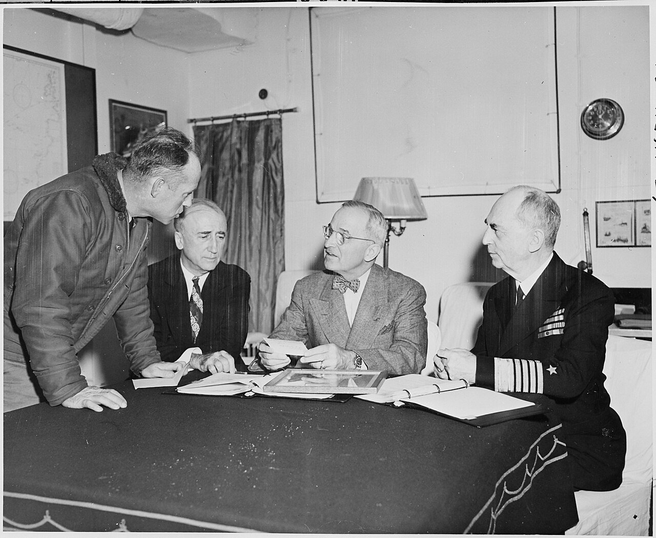President Harry S. Truman receives the latest weather report as he discusses preparations for the Potsdam Conference…