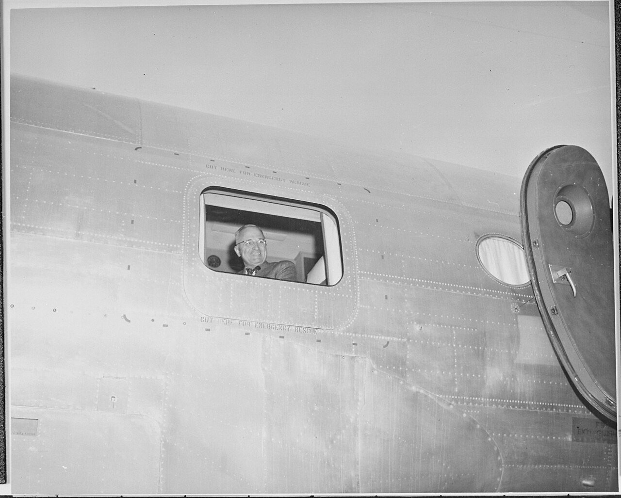 President Truman at the window of his airplane "The Sacred Cow," leaving Gatow Airport in Berlin for England.…