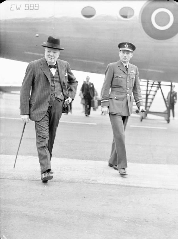 Royal Air Force Transport Command, 1943-1945. The Prime Minister, Winston Churchill, accompanied by Air Marshal the Hon. Sir Ralph Cochrane, Air Officer Commanding in Chief, Transport Command, walks from his Douglas Skymaster Mark I, EW999, at Northolt, Middlesex, on his return from the Three Power Conference at Potsdam.
