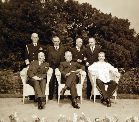80-G-700277: Potsdam Conference, 17 July – 2 August 1945. Prime Minister Clement Atlee; President Harry S. Truman and Premier Joseph Stalin posing in garden at Potsdam, Germany. In back are Fleet Admiral William D. Leahy; Ernest Bevin; Secretary of State James F. Byrnes, and V. Molotov. Photographed released July 31, 1945. U.S. Navy Photograph, now in the collections of the National Archives. (2016/02/23).
