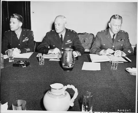 Chiefs of Staff, L to R, Maj. Gen. Lauris Norstad, Gen. Henry H. Arnold, and Gen. George C. Marshall at a meeting…