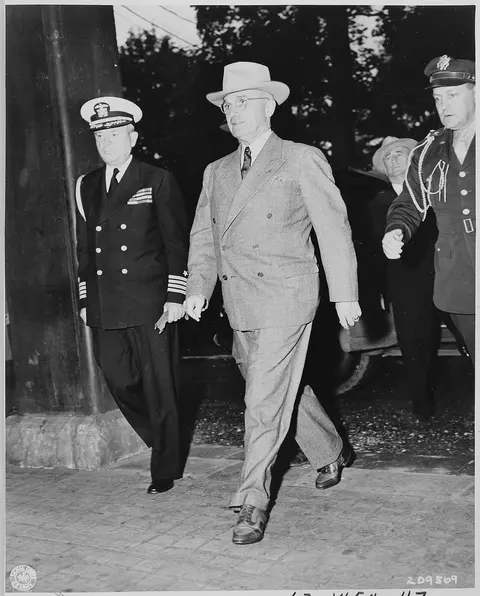 President Harry S. Truman enters Cecilienhof Palace to attend one of the meetings of the Potsdam Conference. L to R…