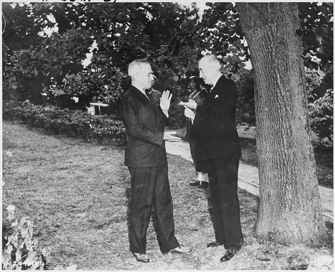 President Harry S. Truman (left) and Secretary of State James Byrnes talk together on the grounds of the "Little…