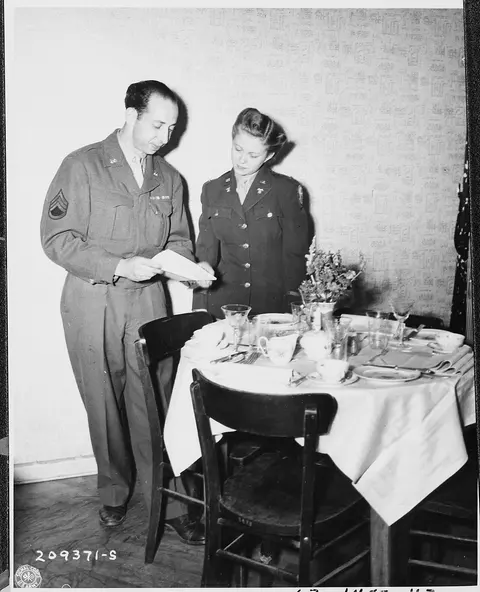 S. Sgt. John Schwarts, mess sergeant, discusses the details of the day's menu with Lt. May Felts, dietician at the…