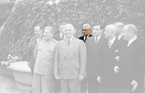 Harry S. Truman and Joseph Stalin meeting at the Potsdam Conference on 18 July 1945. From left to right, first row: Stalin , Truman , Soviet Ambassador Gromyko , US Secretary of State Byrnes , and Soviet Foreign Minister Molotov . Second row: Truman confidant Vaughan [1] , Russian interpreter Bohlen , Truman naval aide Vardaman , and Ross (partially obscured).